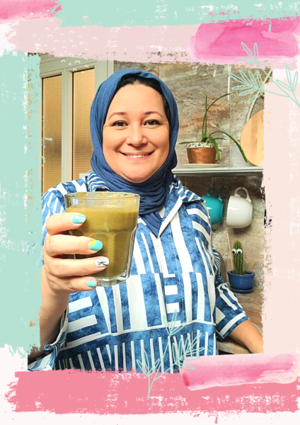 muslim woman holding glass of green smoothie