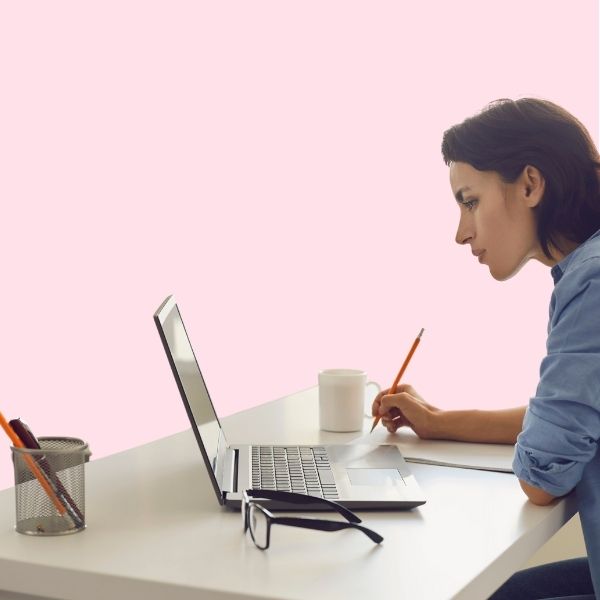 women sat at desk with laptop studying